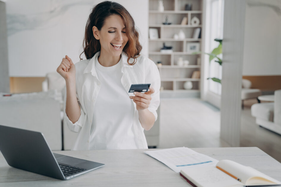 Crédito ou Débito: Qual a Melhor Opção para o Seu Bolso em 2025? 1 Mulher feliz ao encontrar a opção de cartão ideal para ela, após uma consultoria financeira